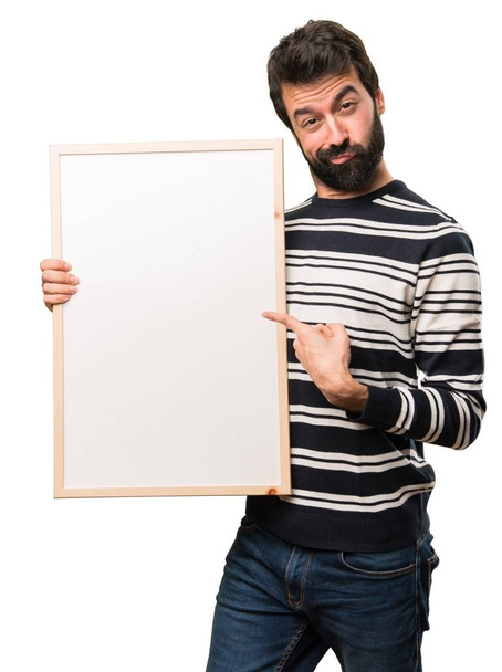Homem com barba segurando um cartaz vazio
 - Foto, Imagem