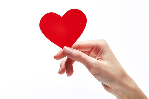 Corazón rojo en mano de mujer aislado en blanco. Día de San Valentín
  - Foto, imagen