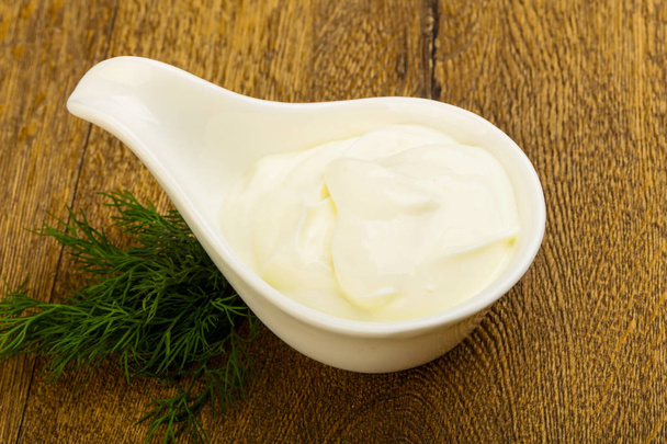 Greek yoghurt with dill leaves on wood background  - Фото, изображение