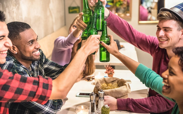 Мультирасовые друзья группа пить и тост пиво в коктейль-баре ресторан - Концепция дружбы с молодыми людьми, наслаждаясь время вместе и весело провести время в прохладном кафе моды - Сосредоточьтесь на бутылки
 - Фото, изображение