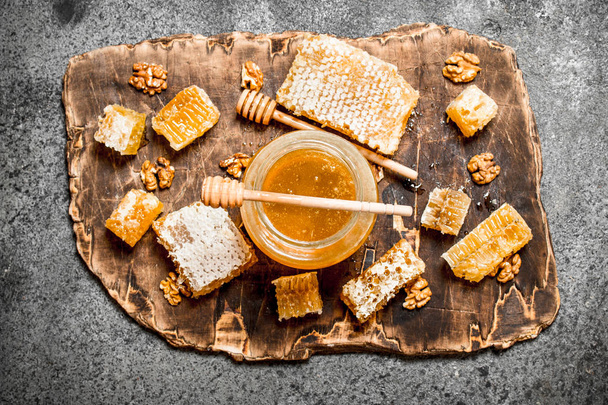 Fresh honey in a jar and honeycomb with nuts. - Фото, зображення