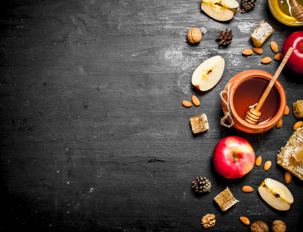 Honey background. Honey in pot with slices of ripe apples and nuts. - Φωτογραφία, εικόνα