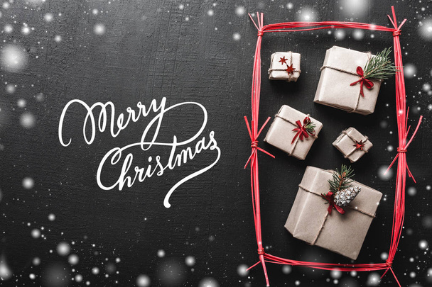 Різдвяна листівка, на чорному тлі, подарунки ручної роботи в червоному прямокутнику. Веселий різдвяний напис з ефектом білої сніжинки
. - Фото, зображення