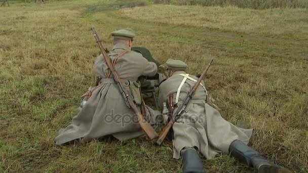 El equipo ruso de ametralladoras formado por dos soldados del antiguo ejército ruso sirve a la ametralladora Maxim. Preparación para el disparo, cinta de ametralladora.Reconstrucción de la Primera Guerra Mundial de 1914-1918. - Imágenes, Vídeo
