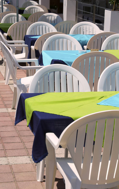 tables of an alfresco cafe with white chairs - Photo, Image