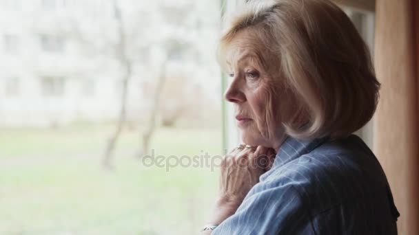 traurige alte Frau dreht den Kopf und blickt in die Kamera - Filmmaterial, Video