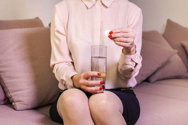 Woman with a glass of water and a pill - Foto, Imagen