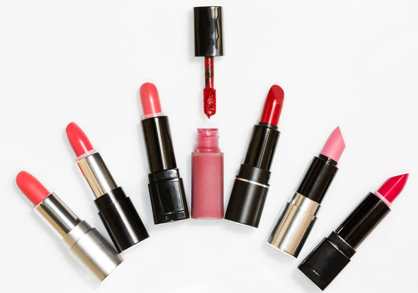 Six lipsticks in stickers and one in a tube with samples on a white background - Photo, Image
