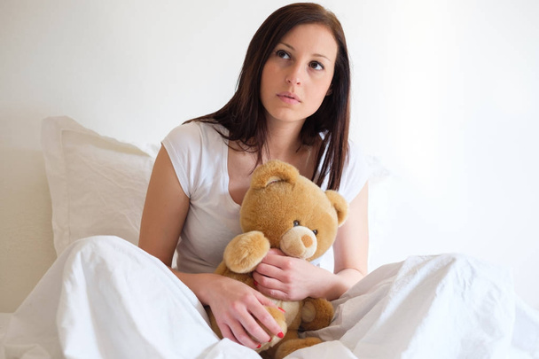 Sad girl getting lonely and hugging soft teddy bear - Foto, afbeelding
