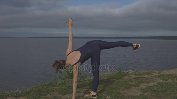 Genç kız bir bacak, eğitim, denge yoga ayakta - Video, Çekim