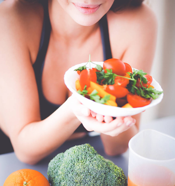 Portrait of smiling young woman with vegetarian vegetable salad. - 写真・画像