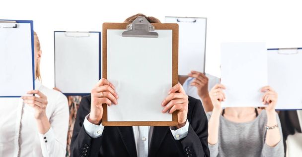 Team of businesspeople holding a folders near face isolated on white background - Фото, зображення