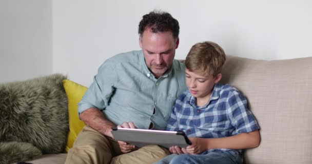 Father and Son looking at a digital tablet - Felvétel, videó