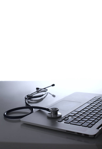 Workplace of doctor with laptop and stethoscope and notebook on white table - Photo, Image