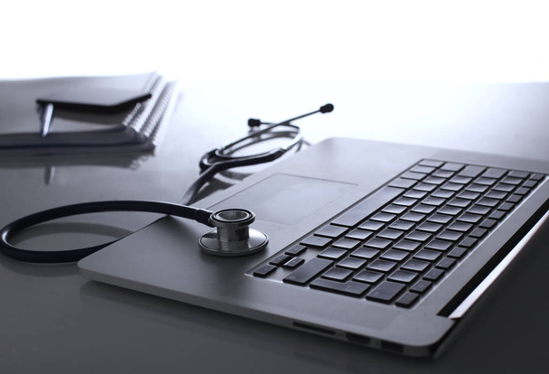 Arbeitsplatz des Arztes mit Laptop und Stethoskop und Notizbuch auf weißem Tisch - Foto, Bild
