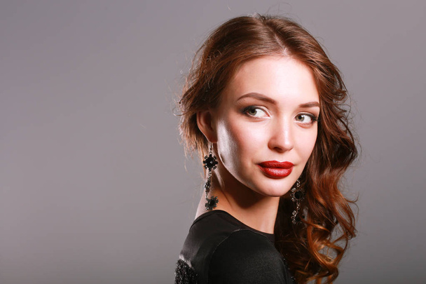 Beautiful woman with evening make-up in black dress - 写真・画像