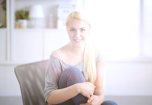 Young beautiful woman sitting on couch at her room - Fotoğraf, Görsel