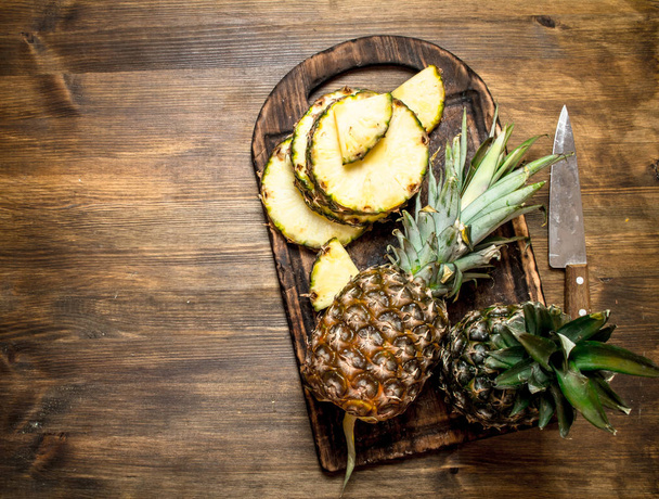 Sliced pineapple on a cutting Board with a knife. - Zdjęcie, obraz