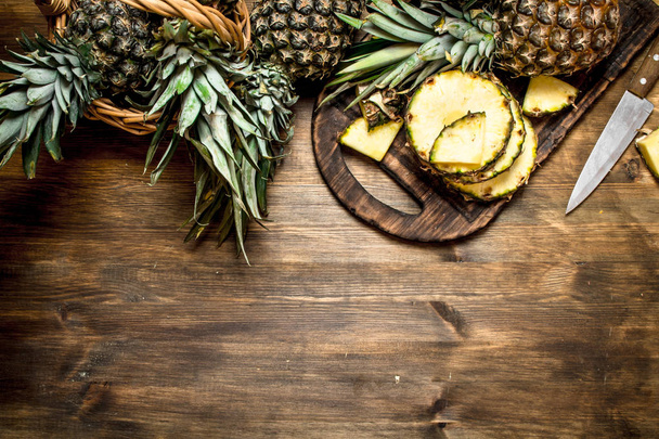 Sliced pineapple on a cutting Board with a knife. - 写真・画像