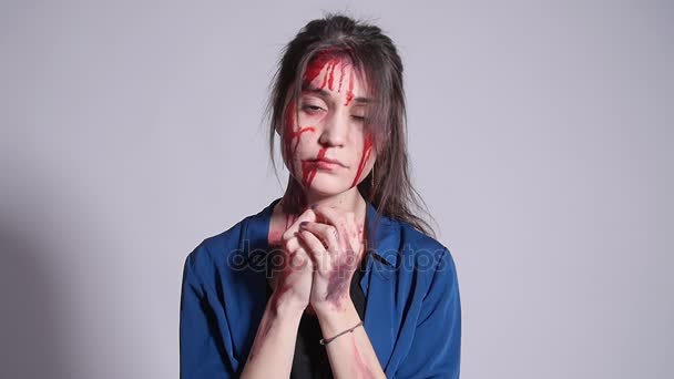 Een jonge vrouw die het slachtoffer zijn geworden van huiselijk geweld. Kneuzingen en bloed op het gezicht - Video