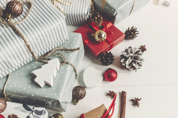 Різдвяна квартира лежить з подарунковими коробками сільського кольору з прикрасами на білому дерев'яному фоні, вид зверху
 - Фото, зображення
