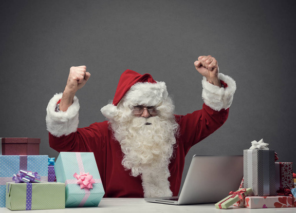 Cheerful Santa connecting with his laptop - Foto, Bild