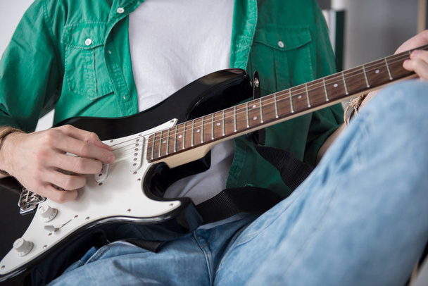 Male rock guitarist performing music on amp - Foto, Bild