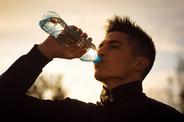 Jonge man drinkwater - Foto, afbeelding