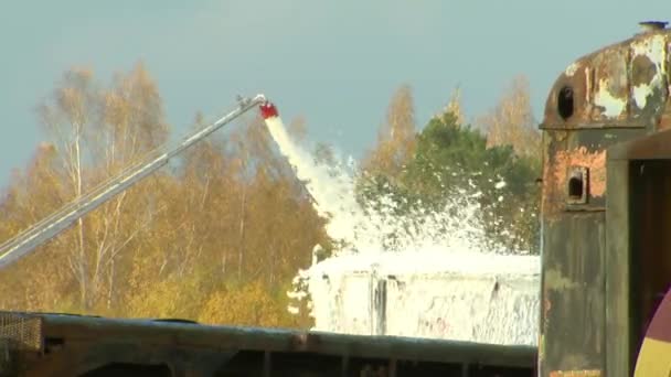 Ein Brennstofftank und ein Reaktor brennen, Feuerwehrleute löschen den Brand mit Schaum - eine Umweltkatastrophe. - Filmmaterial, Video
