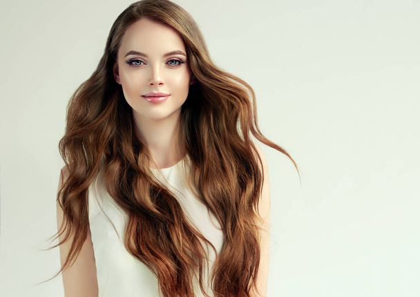 Barna lány hosszú, fényes, hullámos haj. Gyönyörű modell nő göndör frizura. És kozmetikai haj - Fotó, kép