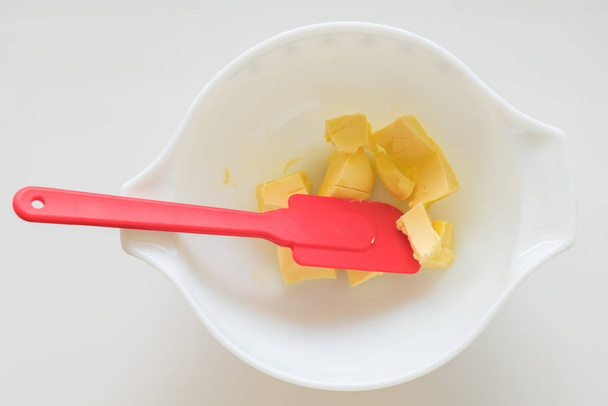 Mantequilla en tazón de mezcla con espátula de silicona
 - Foto, Imagen