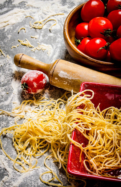 Noodles with tomatoes and a rolling pin.  - Foto, imagen