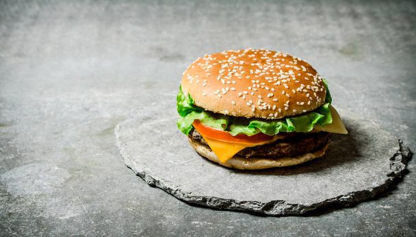 Fresh Burger with cheese and meat on a stone stand.  - Foto, Bild