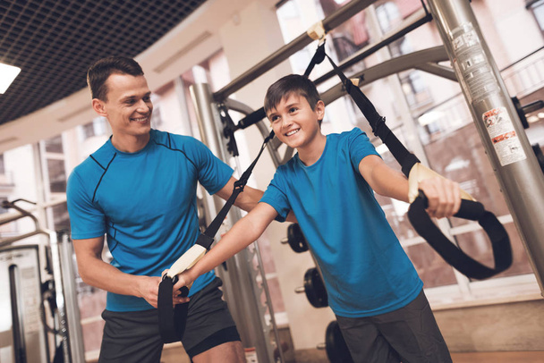 Dad and son in the same clothes in gym. Father and son lead a healthy lifestyle. - Foto, imagen