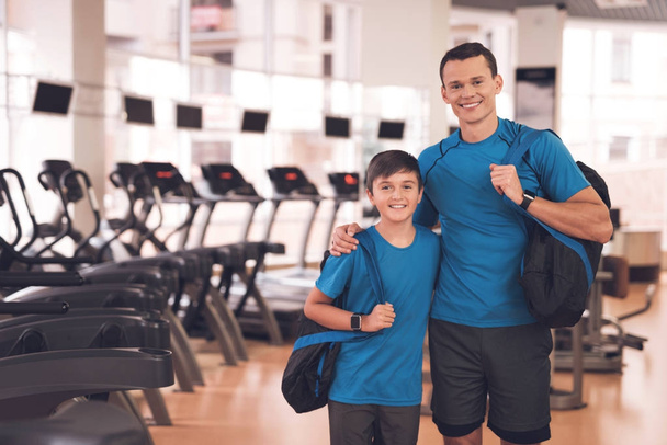 Dad and son in the same clothes in gym. Father and son lead a healthy lifestyle. - Фото, изображение
