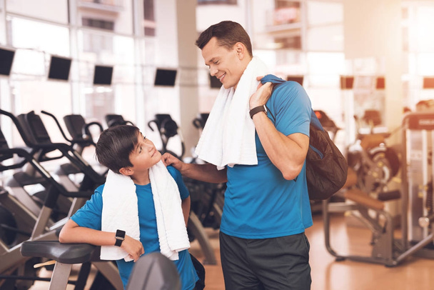 Dad and son in the same clothes in gym. Father and son lead a healthy lifestyle. - Fotó, kép