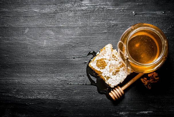 Honey background. Natural honey comb and a glass jar.  - Foto, afbeelding