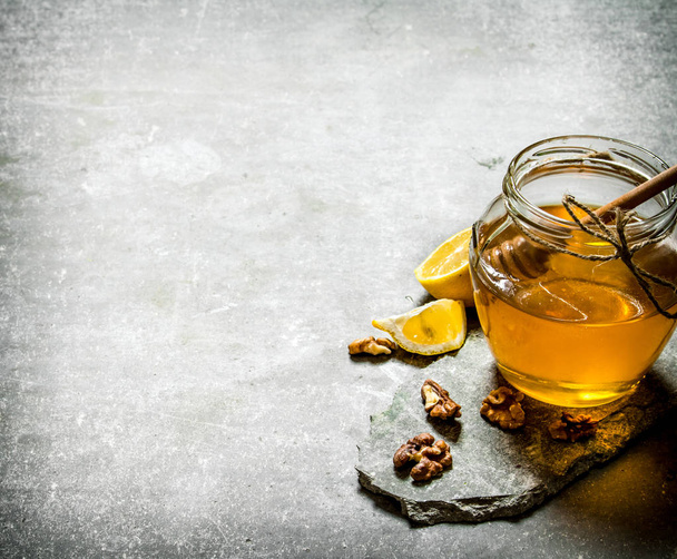 Natural honey in a jar , lemon and walnuts.  - Fotoğraf, Görsel