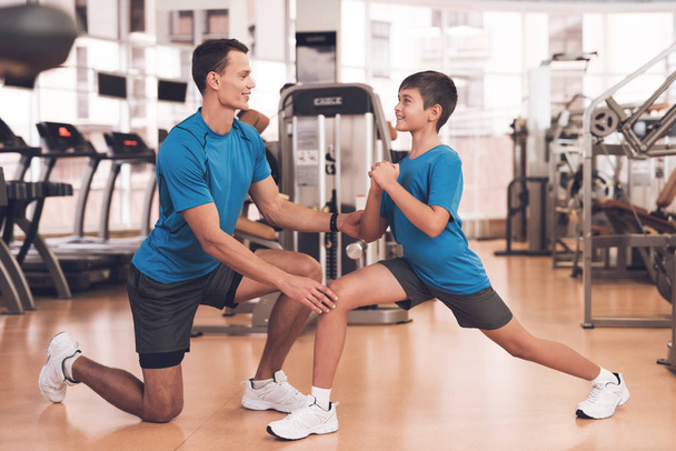 Dad and son in the same clothes in gym. Father and son lead a healthy lifestyle. - Фото, зображення