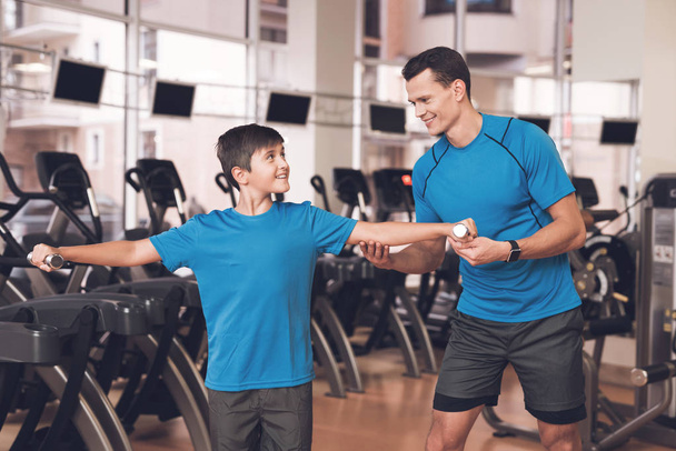 Dad and son in the same clothes in gym. Father and son lead a healthy lifestyle. - Valokuva, kuva