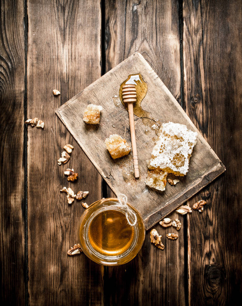 Natural honey in honeycombs with a spoon on the Board. - Foto, imagen
