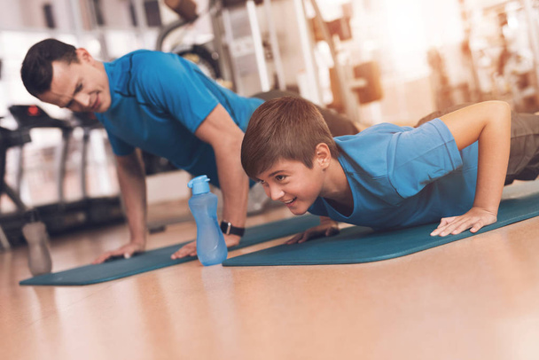 Dad and son in the same clothes in gym. Father and son lead a healthy lifestyle. - Фото, зображення