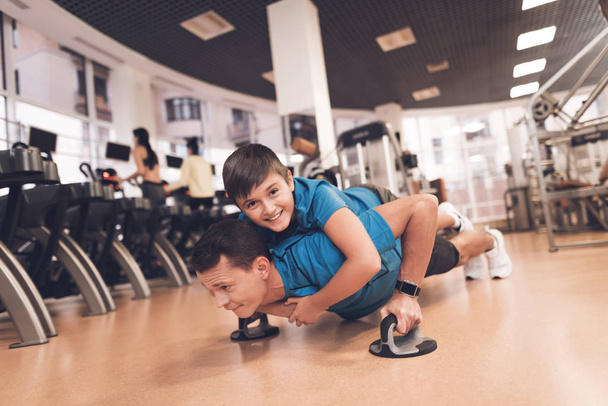 Dad and son in the same clothes in gym. Father and son lead a healthy lifestyle. - Photo, image