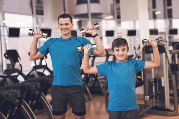 Dad and son in the same clothes in gym. Father and son lead a healthy lifestyle. - Foto, immagini