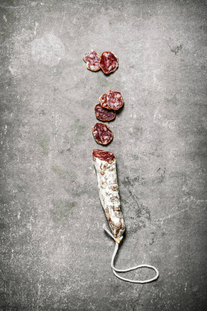 Sliced spicy salami . On stone background.  - Foto, Imagen