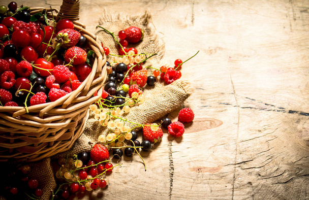 Basket with berries. On wooden table. - Foto, Imagen