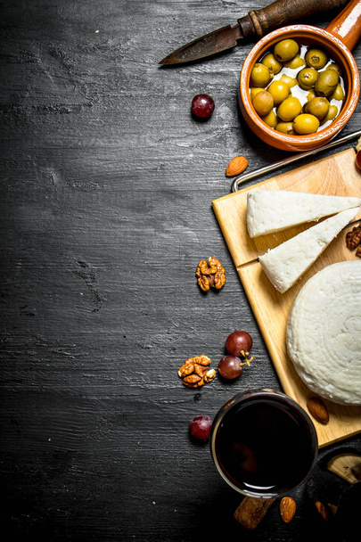 Sheep cheese with red wine , nuts and olives. - Foto, Bild