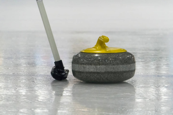 Βούρτσα και κίτρινο Κέρλινγκ πέτρα στον πάγο - Φωτογραφία, εικόνα
