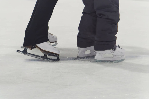 child and adult skates at the ice rink - Photo, Image
