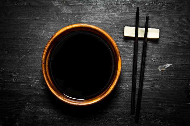 Soy sauce in a bowl and chopsticks. - Photo, Image